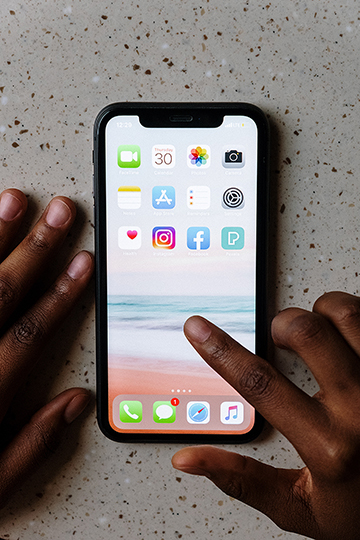 Hand tippt auf Handybildschirm mit Apps